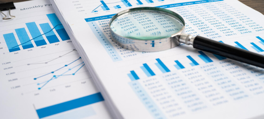 magnifying glass and statistic printouts