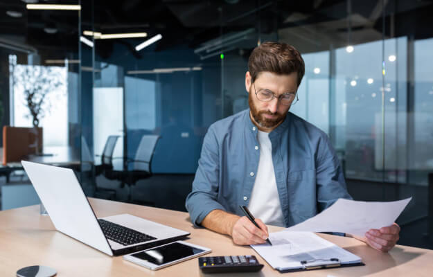 serious focused financier accountant paper work inside office mature man using calculator